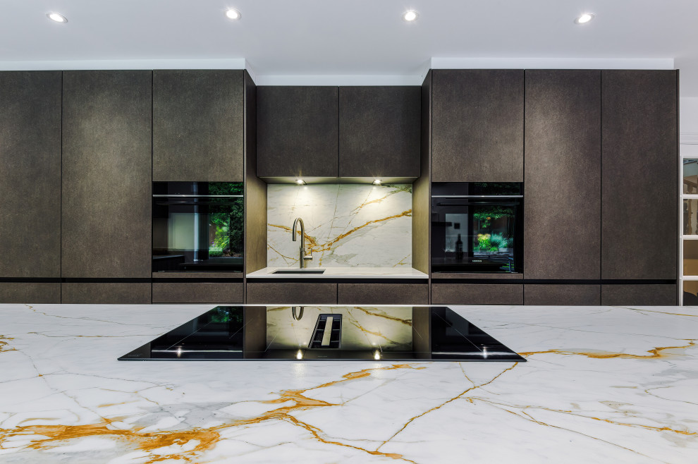 Photo of a medium sized modern galley kitchen/diner in Manchester with stainless steel appliances and an island.