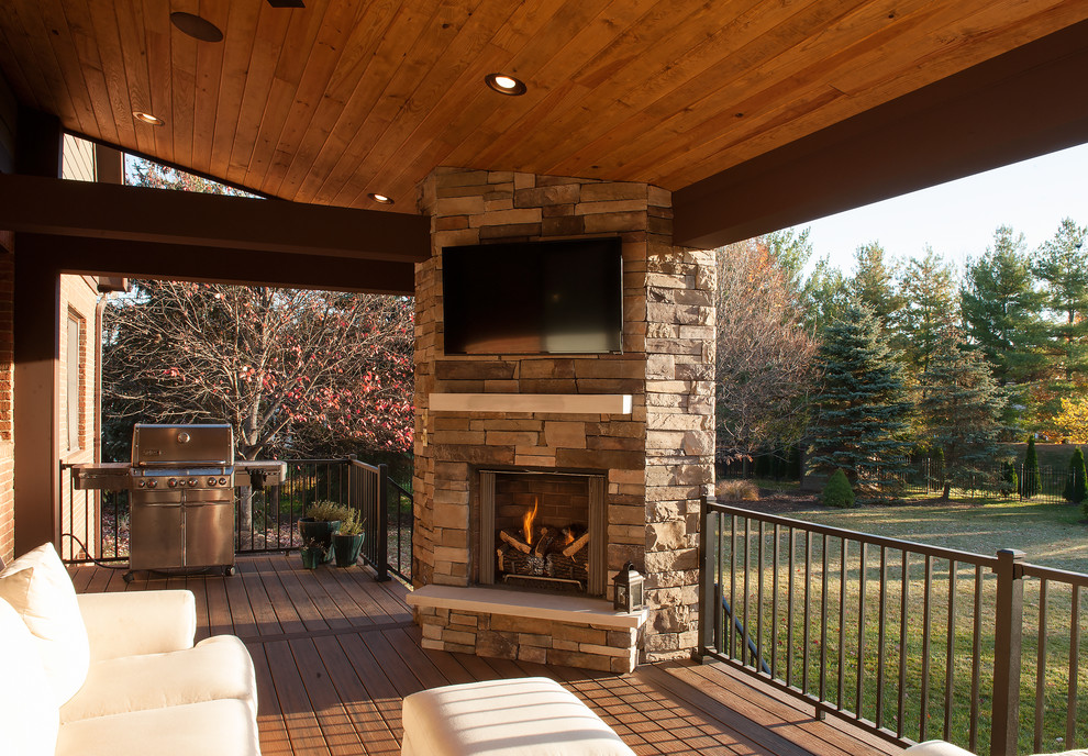 Design ideas for a large transitional backyard deck in Indianapolis with a fire feature and a roof extension.