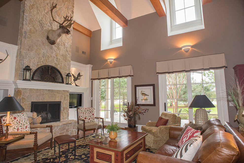 Large arts and crafts enclosed family room in Atlanta with beige walls, medium hardwood floors, a standard fireplace, a stone fireplace surround and a freestanding tv.