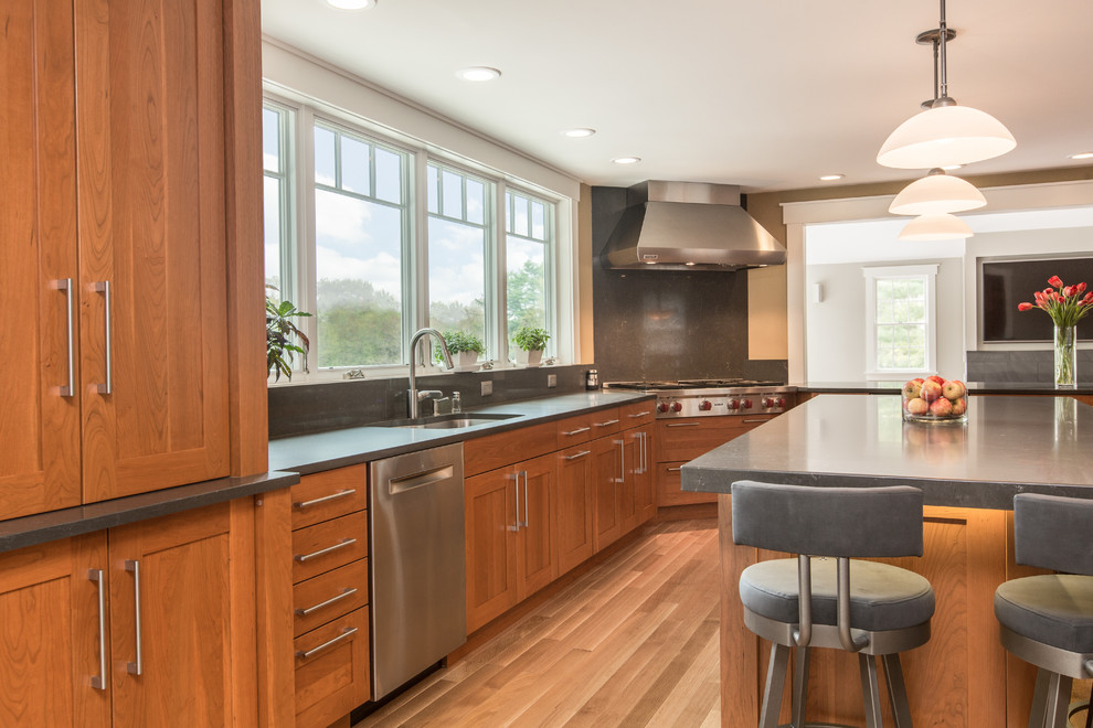 Eat-in kitchen - transitional u-shaped medium tone wood floor eat-in kitchen idea in Boston with an undermount sink, shaker cabinets, medium tone wood cabinets, quartz countertops, gray backsplash, stone slab backsplash, stainless steel appliances and an island