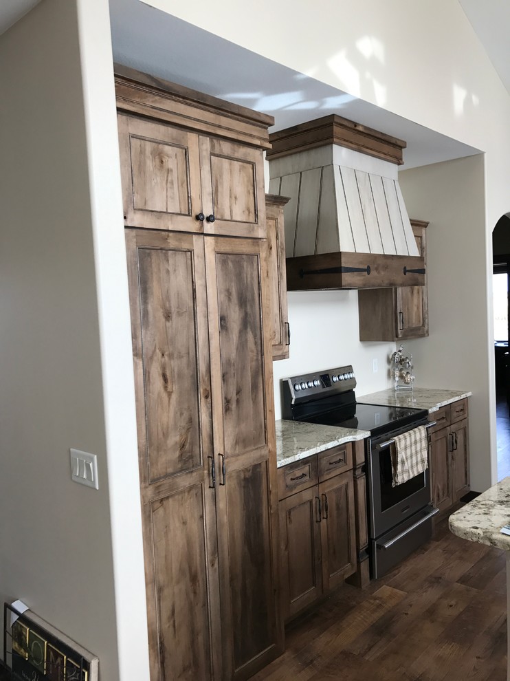 Open concept kitchen - large traditional dark wood floor and brown floor open concept kitchen idea with flat-panel cabinets, distressed cabinets, granite countertops and an island