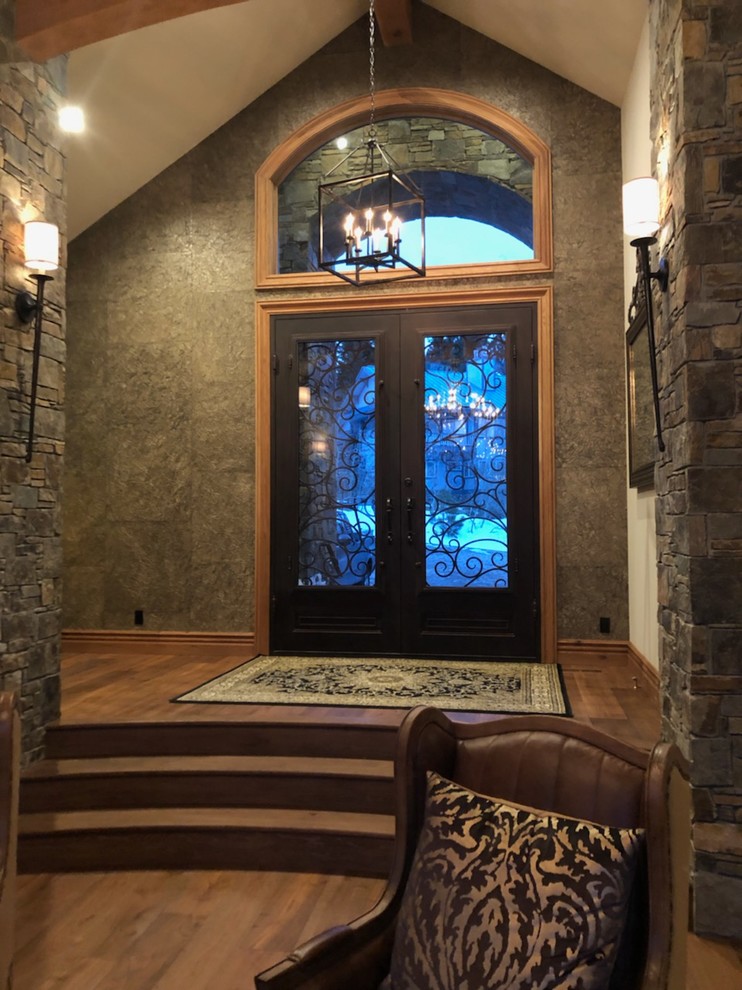 Inspiration for a huge rustic medium tone wood floor and brown floor foyer remodel with metallic walls and a brown front door
