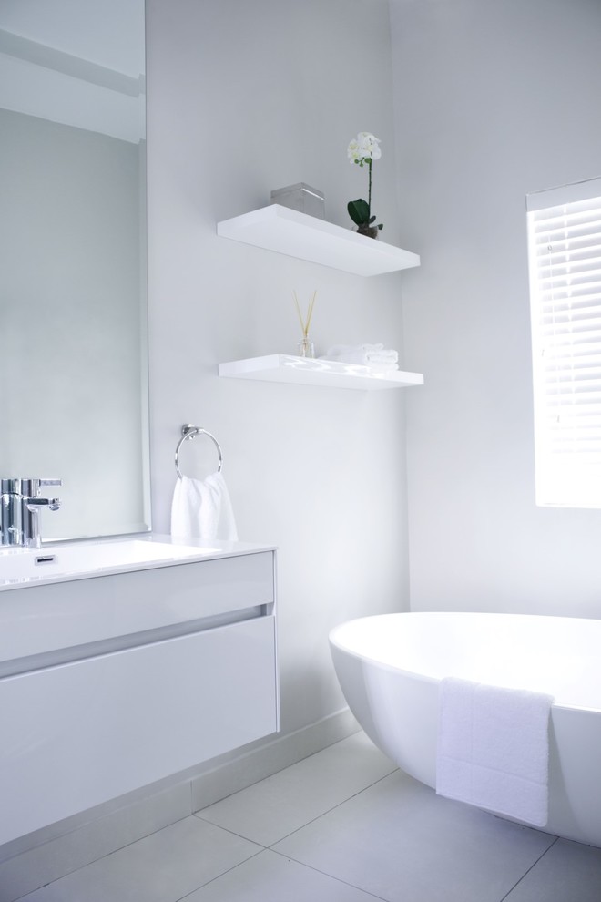 Design ideas for a small contemporary master bathroom in Other with flat-panel cabinets, white cabinets, a freestanding tub, a corner shower, a wall-mount toilet, beige tile, porcelain tile, white walls, porcelain floors, an undermount sink and engineered quartz benchtops.