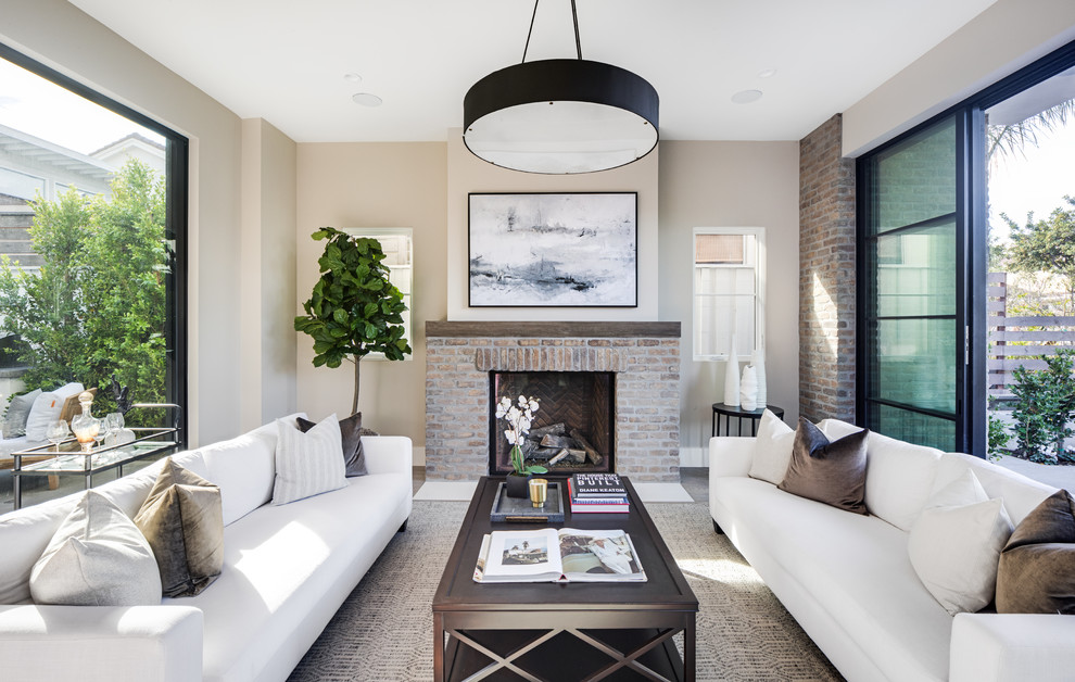 Photo of a transitional formal living room in Los Angeles with beige walls, a standard fireplace, a brick fireplace surround and no tv.