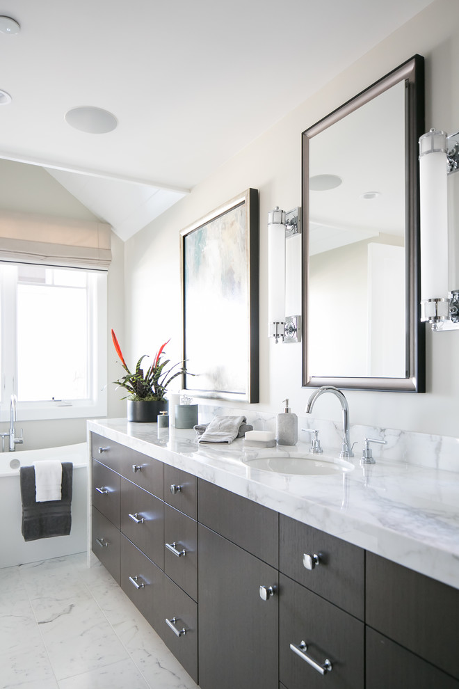 Transitional master bathroom in Orange County with flat-panel cabinets, dark wood cabinets, a freestanding tub, ceramic floors, granite benchtops, grey walls, an undermount sink, white floor and white benchtops.