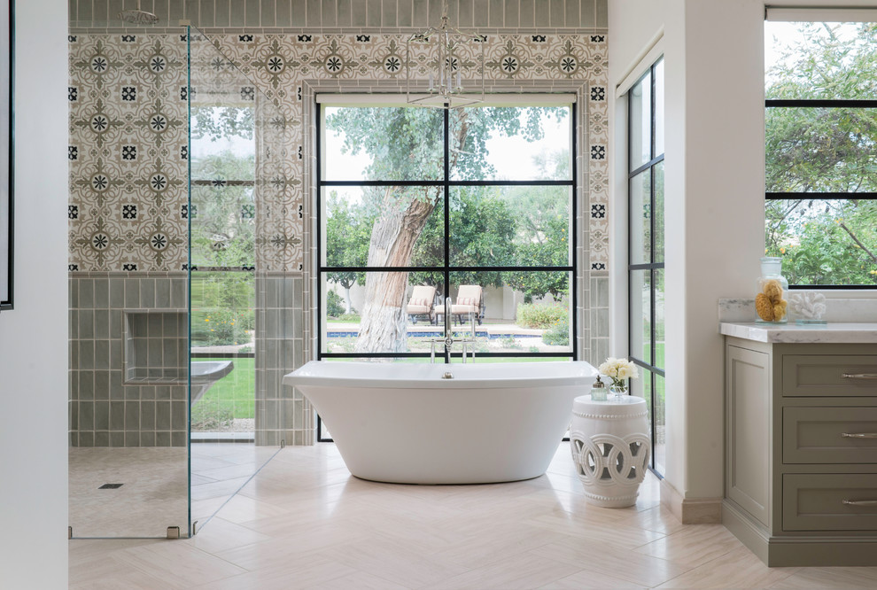 Inspiration for a transitional master bathroom in Phoenix with shaker cabinets, grey cabinets, a freestanding tub, a curbless shower, gray tile, multi-coloured tile, beige floor and cement tile.