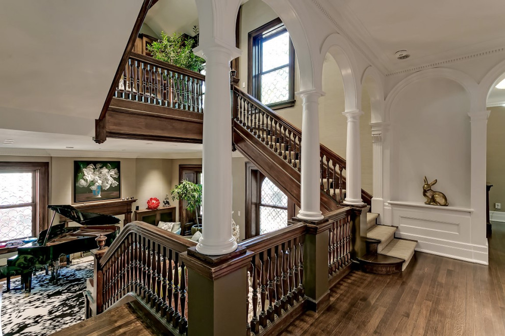 Design ideas for an expansive traditional wood u-shaped staircase in Toronto with wood risers and wood railing.