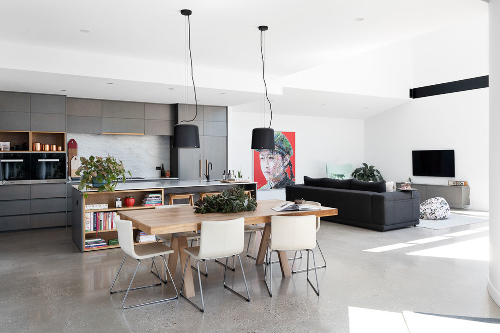 This is an example of a large contemporary dining room in Melbourne with white walls, concrete floors, a hanging fireplace and grey floor.