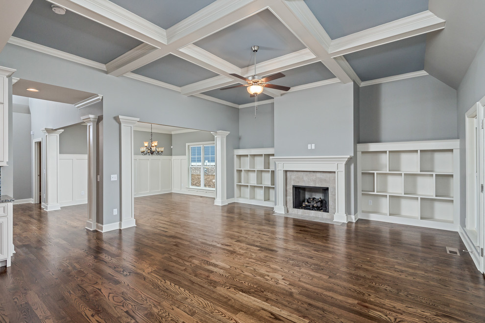 Inspiration for a mid-sized arts and crafts open concept family room in Other with grey walls, medium hardwood floors, a standard fireplace, a tile fireplace surround and no tv.