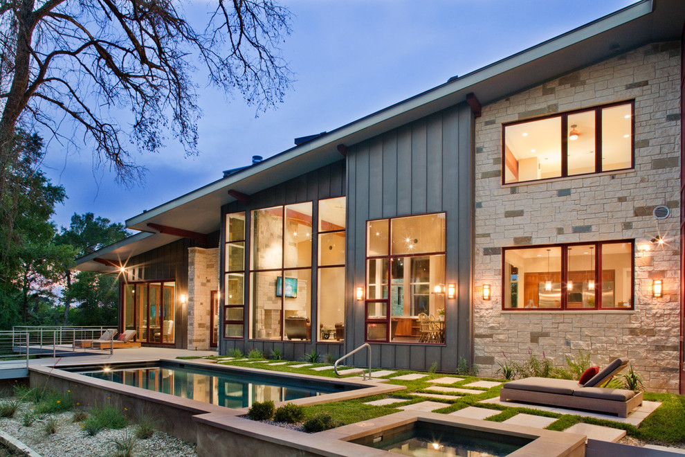This is an example of a large contemporary two-storey grey house exterior in Austin with mixed siding, a shed roof and a shingle roof.