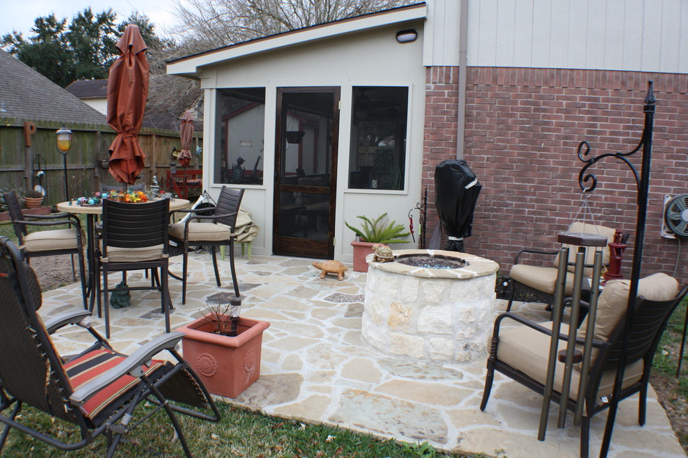 Inspiration for a mid-sized traditional backyard patio in Houston with a fire feature, natural stone pavers and no cover.