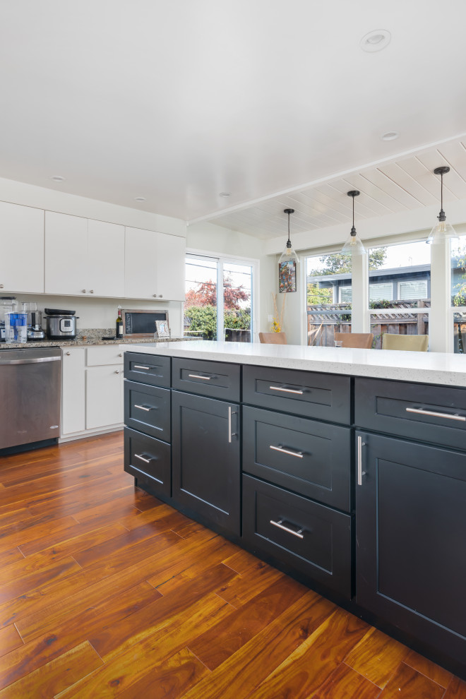 Example of a mid-sized transitional u-shaped dark wood floor and brown floor eat-in kitchen design in San Francisco with an undermount sink, shaker cabinets, black cabinets, quartz countertops, white backsplash, stainless steel appliances, an island and white countertops