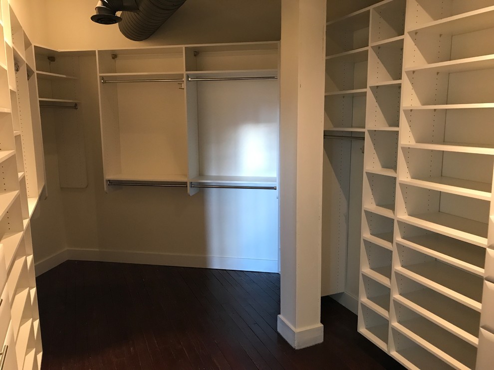 Design ideas for a large traditional walk-in wardrobe in Detroit with white cabinets, dark hardwood floors and brown floor.