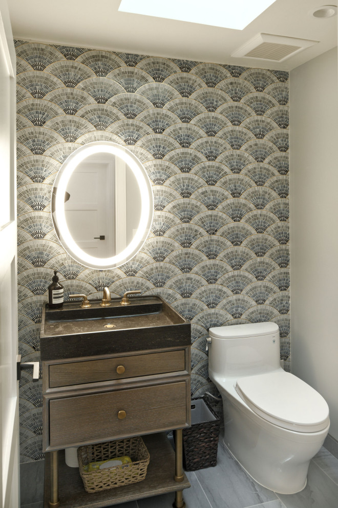 Photo of a small traditional cloakroom in San Francisco with freestanding cabinets, brown cabinets, a one-piece toilet, blue tiles, glass tiles, white walls, marble flooring, an integrated sink, limestone worktops, blue floors, black worktops and a freestanding vanity unit.