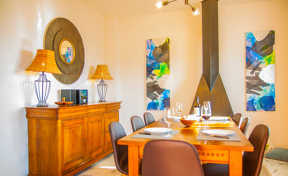 Foto de comedor costero de tamaño medio abierto con paredes beige, suelo de mármol y todas las chimeneas