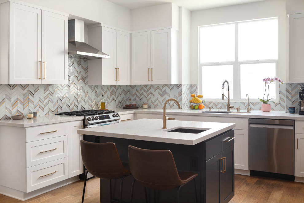 This is an example of a mid-sized transitional u-shaped eat-in kitchen in Los Angeles with an undermount sink, shaker cabinets, white cabinets, quartz benchtops, grey splashback, marble splashback, stainless steel appliances, medium hardwood floors, with island, yellow floor and white benchtop.