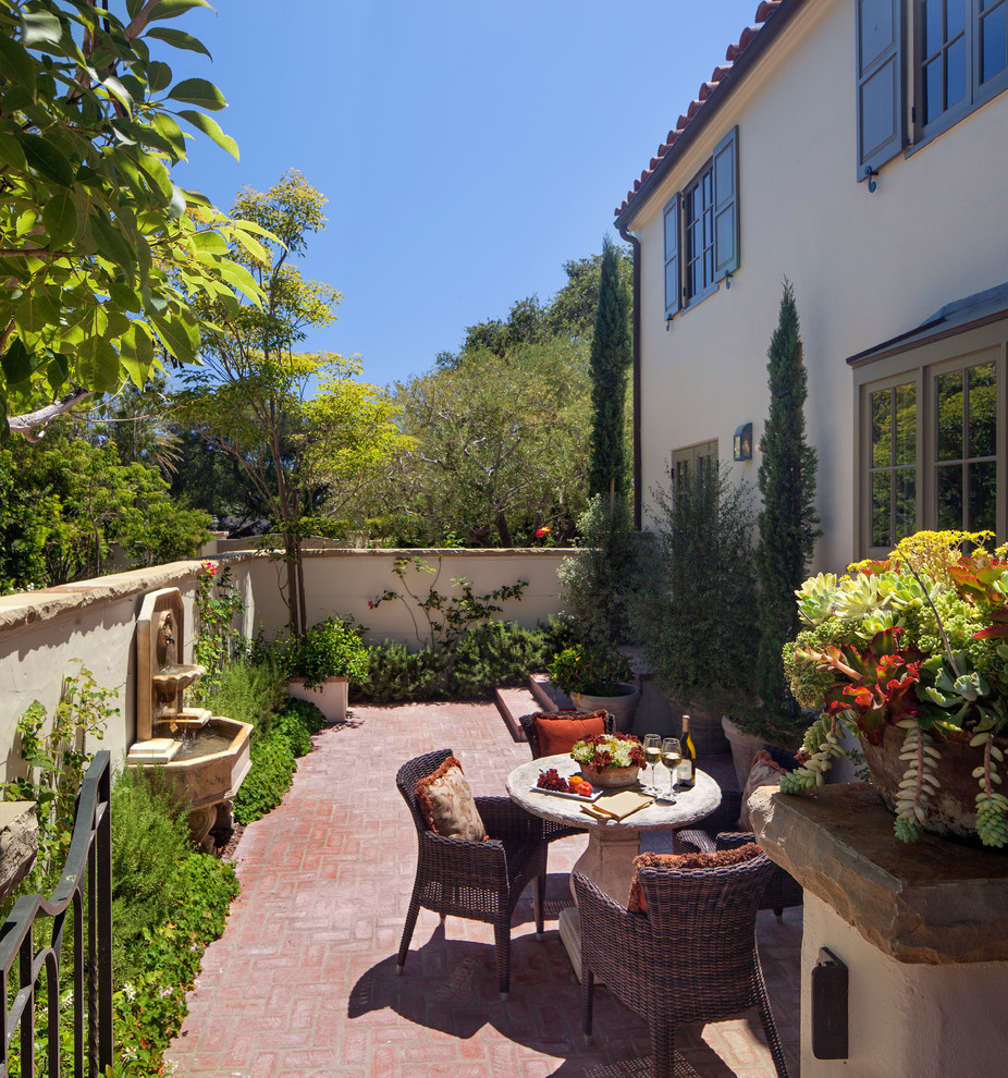 This is an example of a mediterranean patio in Santa Barbara with brick pavers.