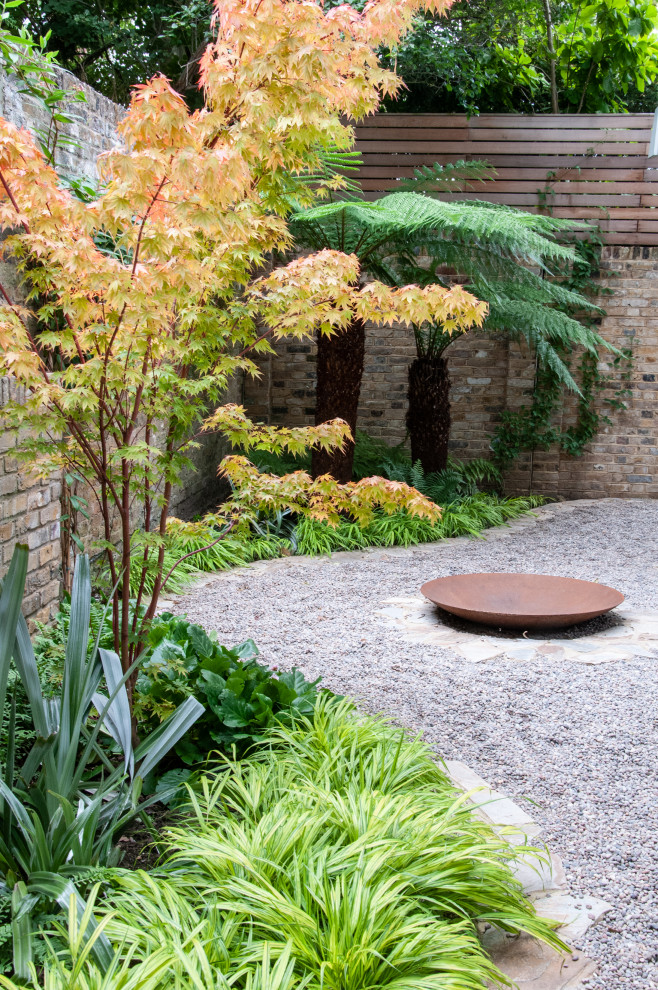 Immagine di un piccolo giardino minimal esposto a mezz'ombra davanti casa in estate con un ingresso o sentiero e pavimentazioni in pietra naturale