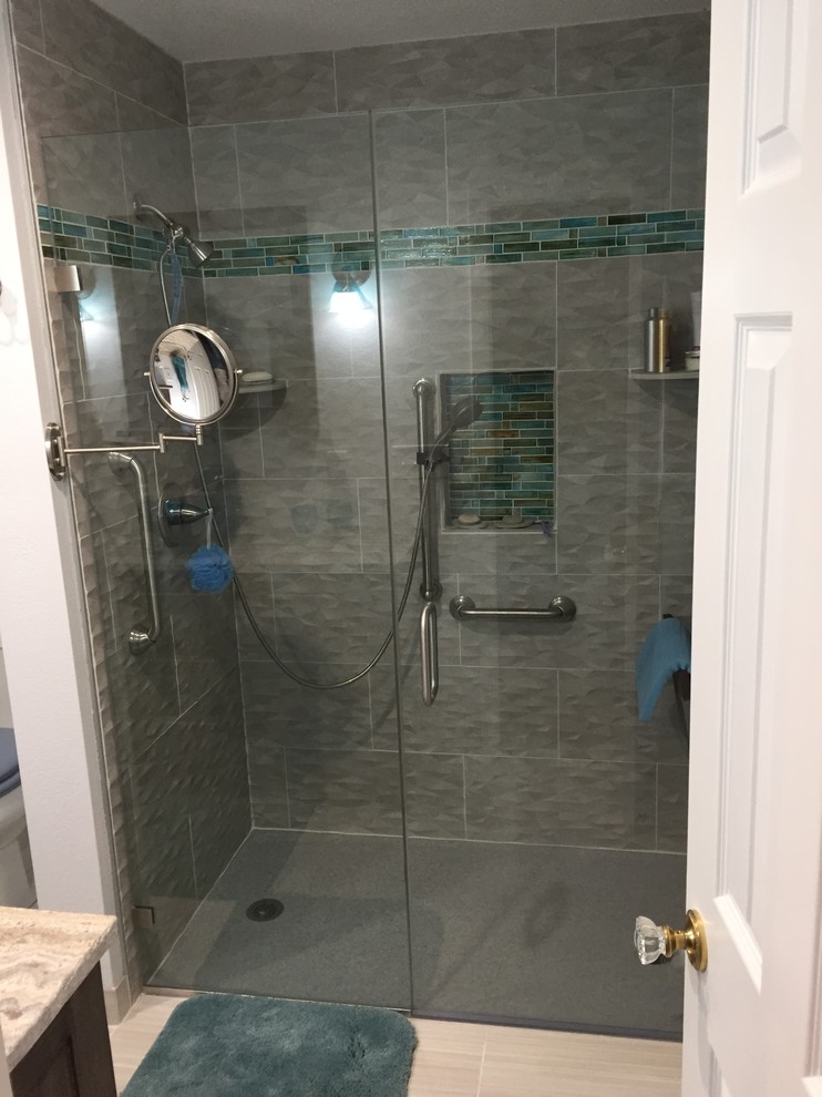 Inspiration for a mid-sized modern bathroom in Denver with recessed-panel cabinets, black cabinets, a drop-in tub, an alcove shower, a two-piece toilet, gray tile, ceramic tile, beige walls, porcelain floors, an integrated sink, engineered quartz benchtops, grey floor, a hinged shower door and grey benchtops.