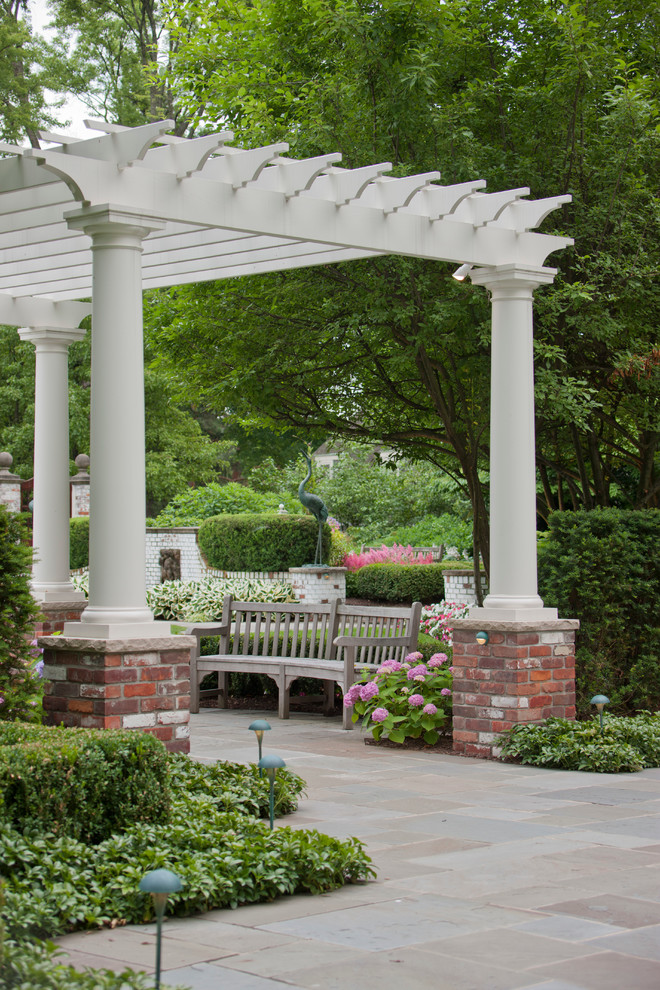 Photo of an expansive traditional backyard formal garden in Detroit with natural stone pavers.