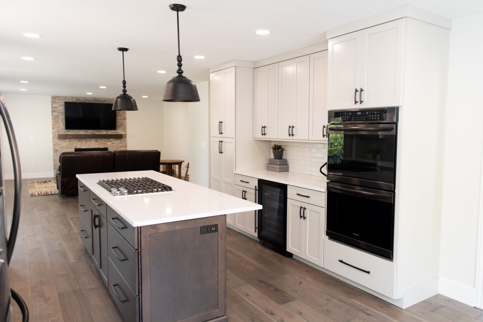 Design ideas for a medium sized farmhouse galley kitchen/diner in Salt Lake City with a belfast sink, shaker cabinets, grey cabinets, engineered stone countertops, white splashback, an island and white worktops.