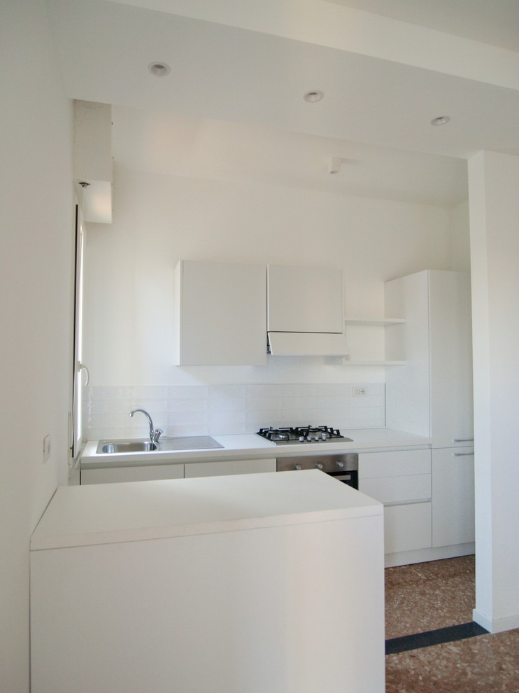 Photo of a small contemporary galley open plan kitchen in Milan with flat-panel cabinets, white cabinets and with island.
