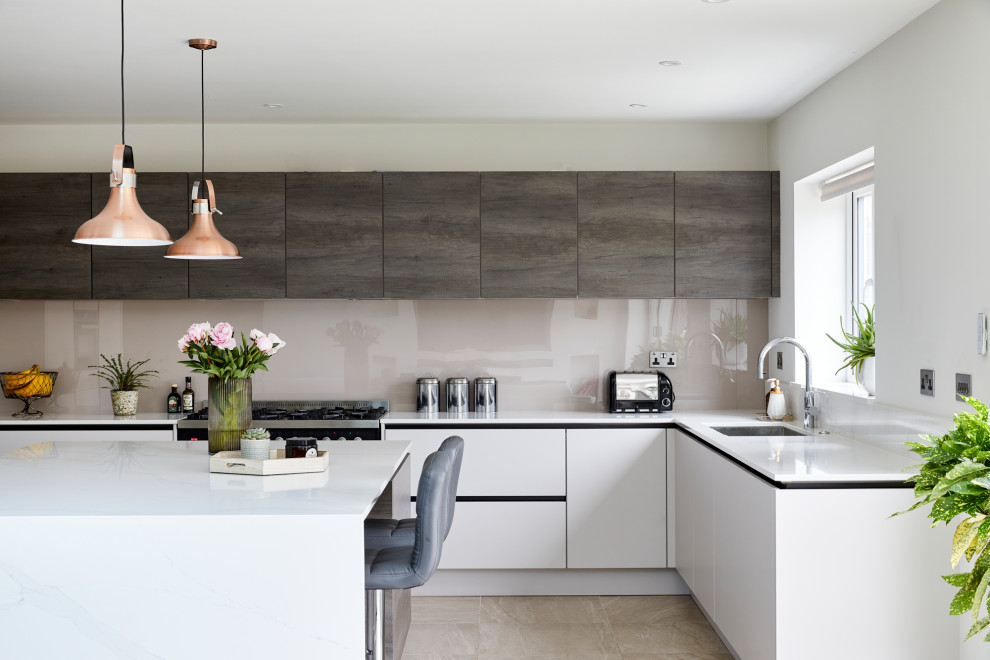 Large modern l-shaped open plan kitchen in London with flat-panel cabinets, grey cabinets, granite benchtops, grey splashback, cement tiles, with island, beige floor and white benchtop.