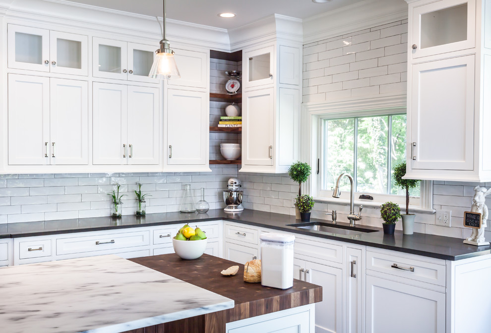 Photo of a large transitional l-shaped eat-in kitchen in New York with an undermount sink, beaded inset cabinets, white cabinets, wood benchtops, white splashback, subway tile splashback, stainless steel appliances, with island and dark hardwood floors.