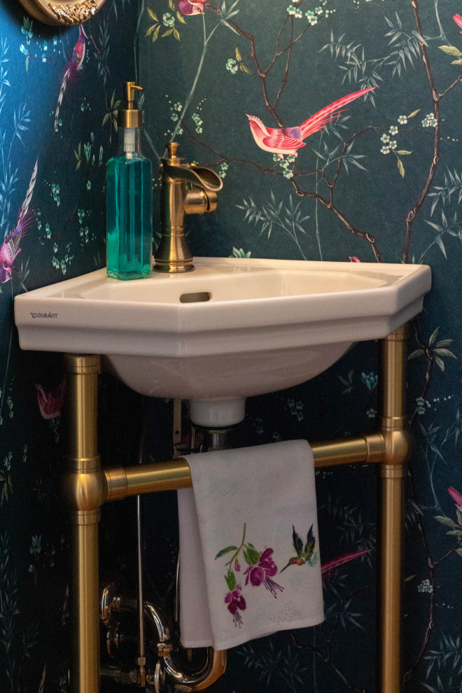 Ispirazione per un piccolo bagno di servizio chic con WC a due pezzi, pareti blu, pavimento in legno massello medio, lavabo a colonna, pavimento marrone e carta da parati