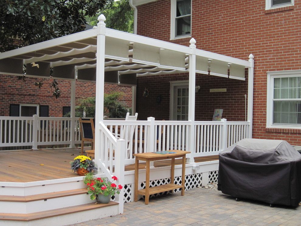 Mid-sized transitional backyard deck photo with a pergola