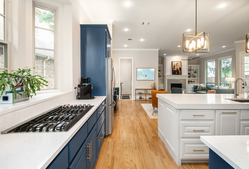 Large transitional single-wall medium tone wood floor and brown floor open concept kitchen photo in Dallas with a single-bowl sink, flat-panel cabinets, blue cabinets, quartz countertops, white backsplash, marble backsplash, stainless steel appliances, an island and white countertops