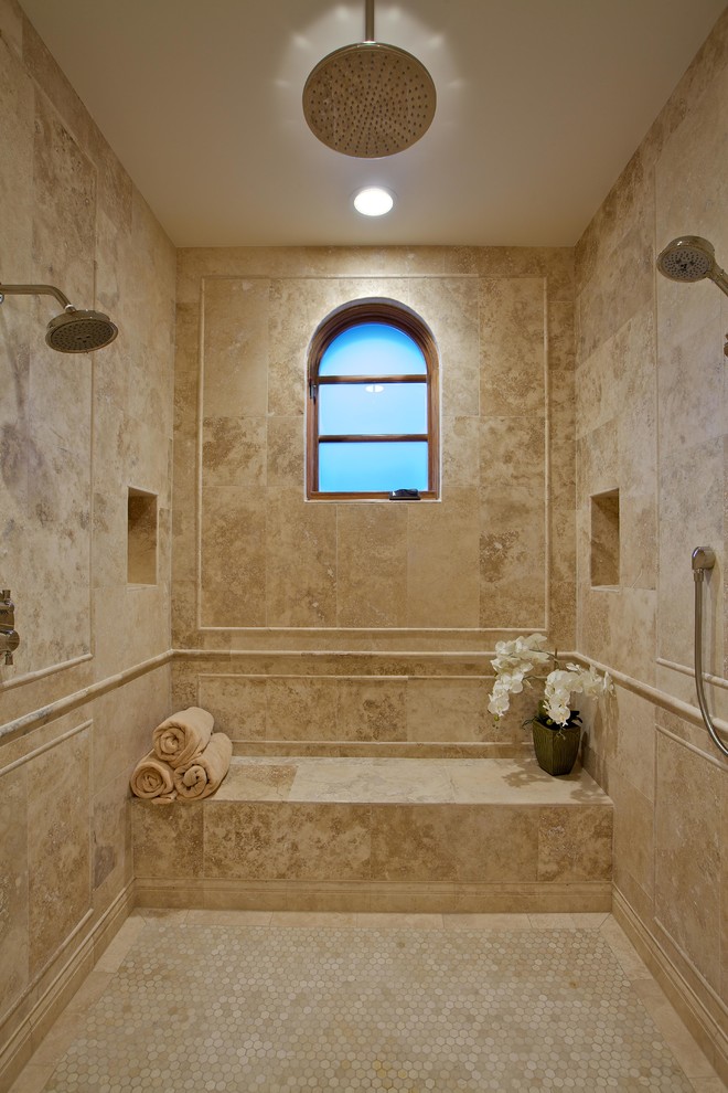 This is an example of a mediterranean master bathroom in San Diego with a double shower.