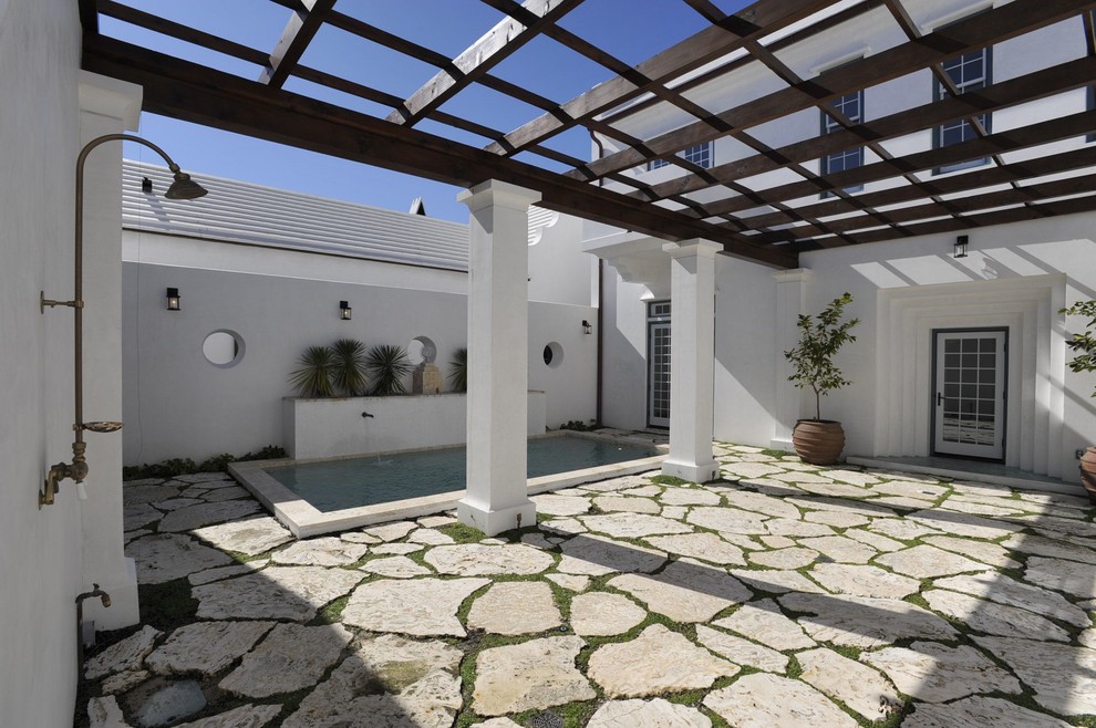 Contemporary patio in Birmingham with natural stone pavers and a pergola.