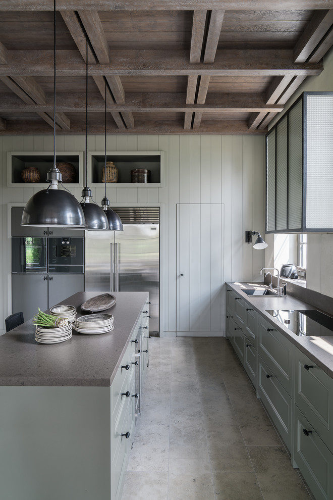 Country single-wall kitchen in Moscow with with island, an undermount sink, recessed-panel cabinets, grey cabinets, grey floor and stainless steel appliances.