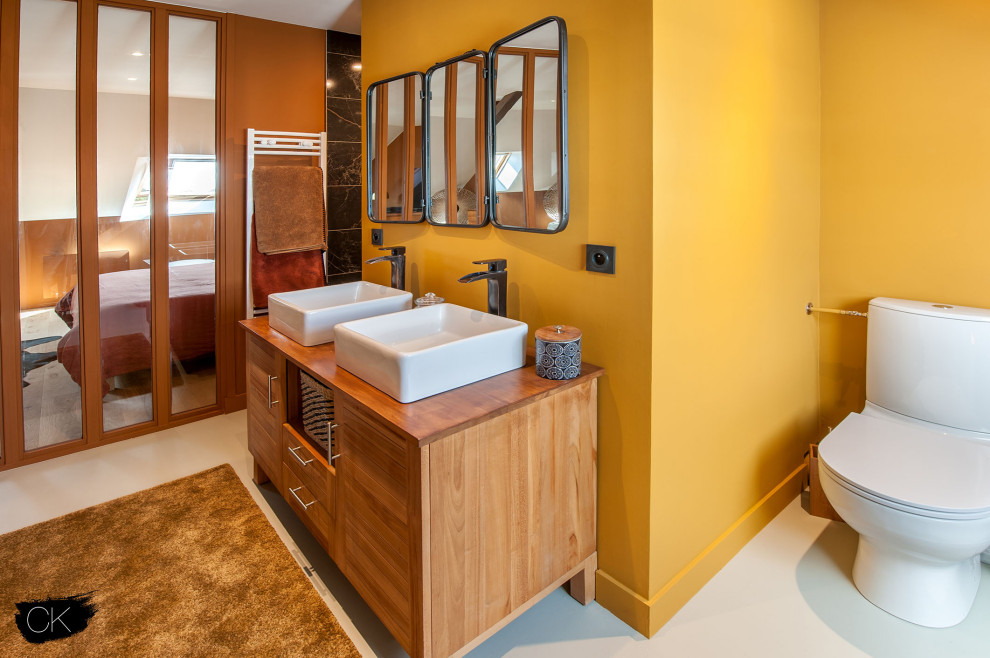 Réalisation d'une salle de bain champêtre de taille moyenne avec un mur jaune et parquet clair.