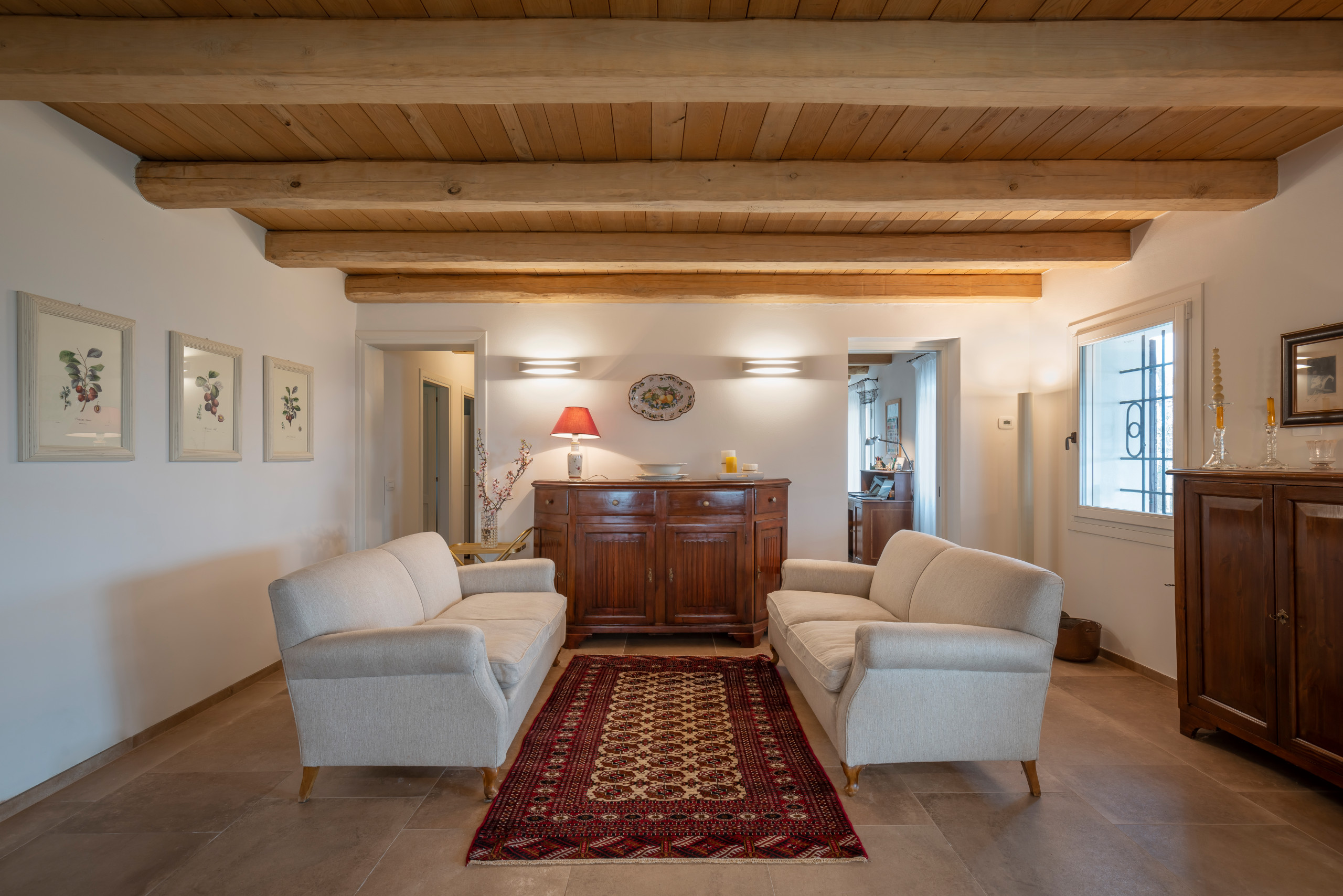 Immagine di un soggiorno country di medie dimensioni e aperto con pareti bianche, pavimento in gres porcellanato, pavimento beige e soffitto in legno