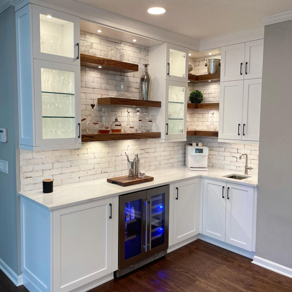 Inspiration for a medium tone wood floor and brown floor kitchen remodel in Atlanta with an undermount sink, recessed-panel cabinets, white cabinets, white backsplash, stainless steel appliances, an island and white countertops