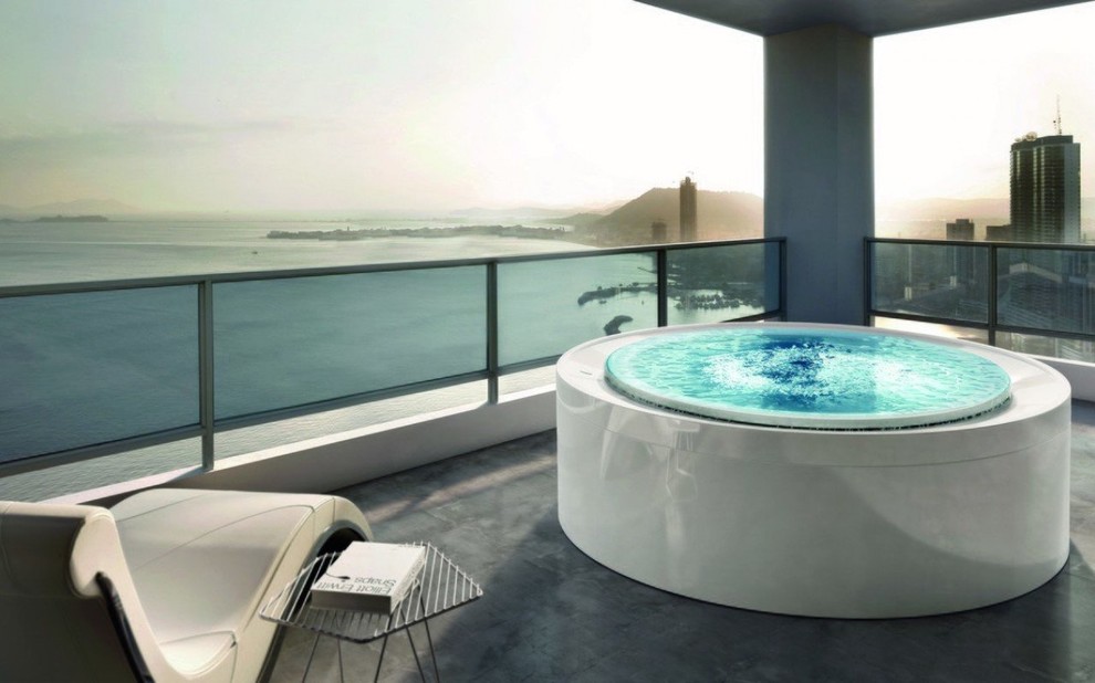 This is an example of an expansive modern rooftop round infinity pool in Miami with a hot tub.