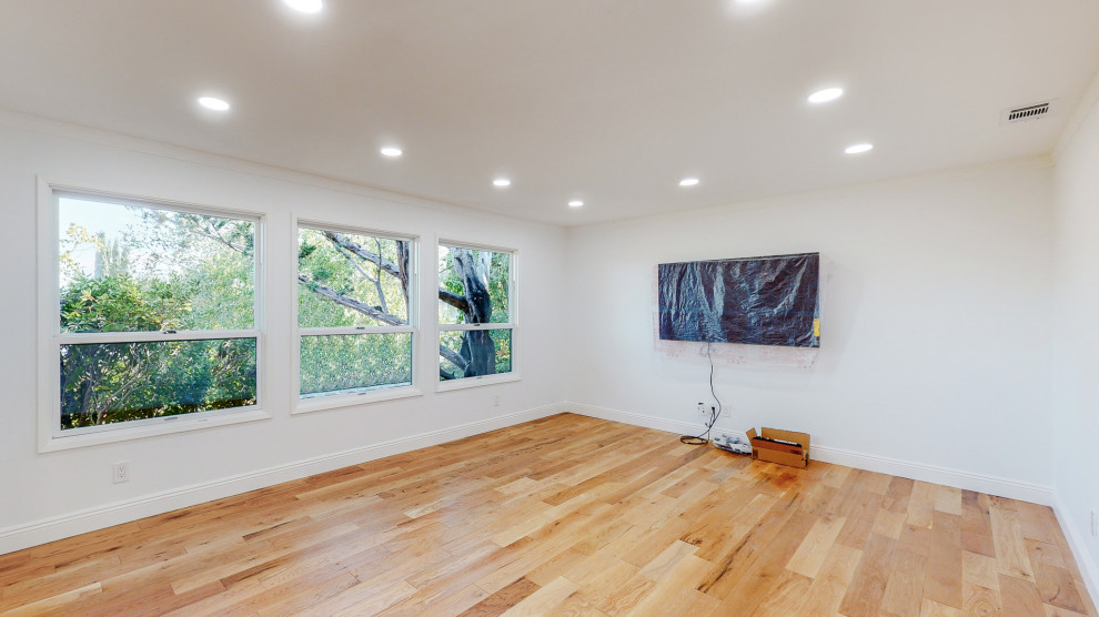 Photo of a medium sized eclectic home gym with white walls, bamboo flooring and beige floors.