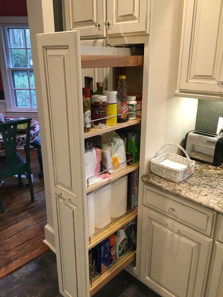 Inspiration for a mid-sized transitional kitchen pantry in Louisville with an undermount sink, raised-panel cabinets, distressed cabinets, granite benchtops, grey splashback, stainless steel appliances, vinyl floors and a peninsula.