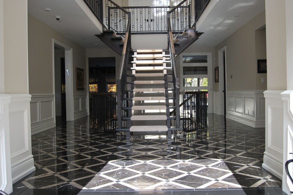 Inspiration for a traditional foyer in Toronto with beige walls, marble floors and black floor.