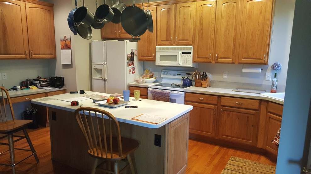 Mid-sized transitional l-shaped medium tone wood floor and red floor eat-in kitchen photo with an undermount sink, raised-panel cabinets, gray cabinets, quartz countertops, gray backsplash, subway tile backsplash, stainless steel appliances, an island and white countertops