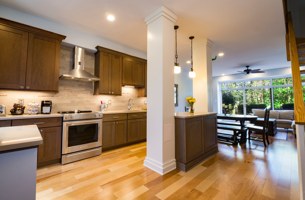 Example of a mid-sized beach style galley light wood floor open concept kitchen design in DC Metro with an undermount sink, shaker cabinets, dark wood cabinets, quartz countertops, gray backsplash, ceramic backsplash, stainless steel appliances and an island