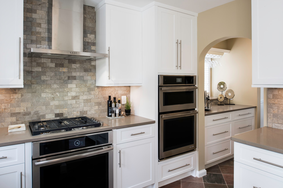 This is an example of a mid-sized modern u-shaped separate kitchen in DC Metro with an undermount sink, shaker cabinets, white cabinets, quartz benchtops, multi-coloured splashback, marble splashback, stainless steel appliances, slate floors, a peninsula and multi-coloured floor.