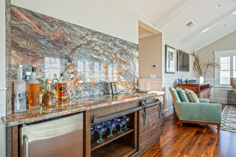 Design ideas for a mid-sized transitional galley seated home bar in Boston with a drop-in sink, flat-panel cabinets, medium wood cabinets, marble benchtops, multi-coloured splashback, marble splashback and dark hardwood floors.