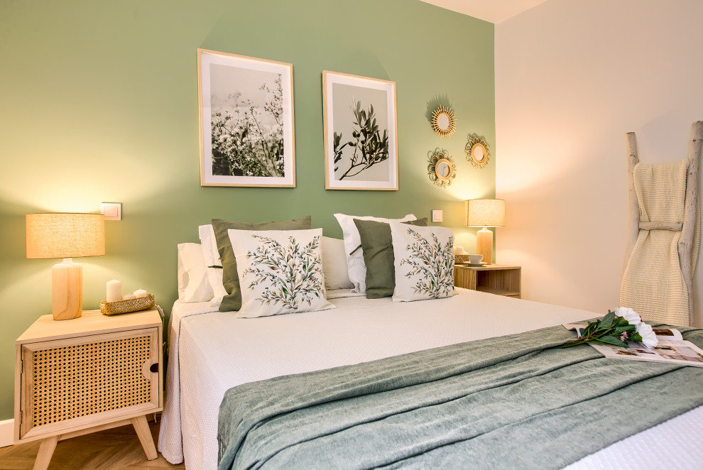 Mittelgroßes Skandinavisches Hauptschlafzimmer mit grüner Wandfarbe, hellem Holzboden und braunem Boden in Madrid