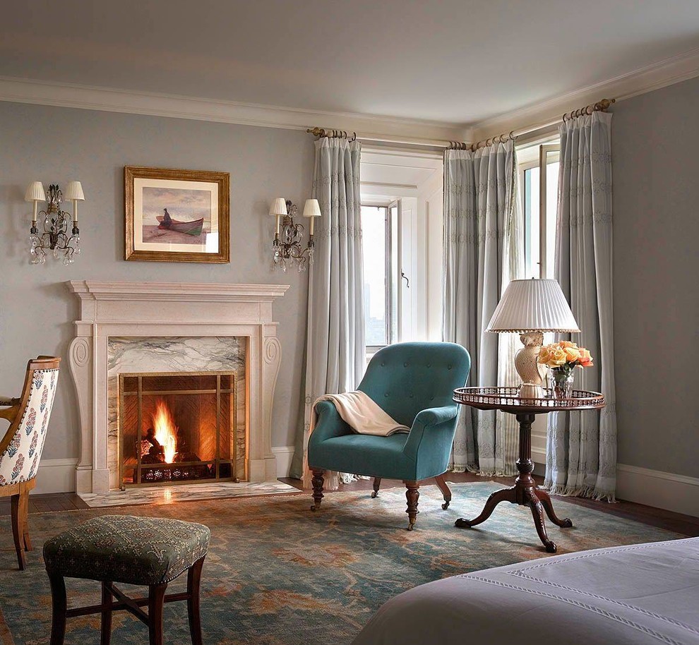 Example of a large classic master dark wood floor bedroom design in New York with gray walls, a standard fireplace and a stone fireplace