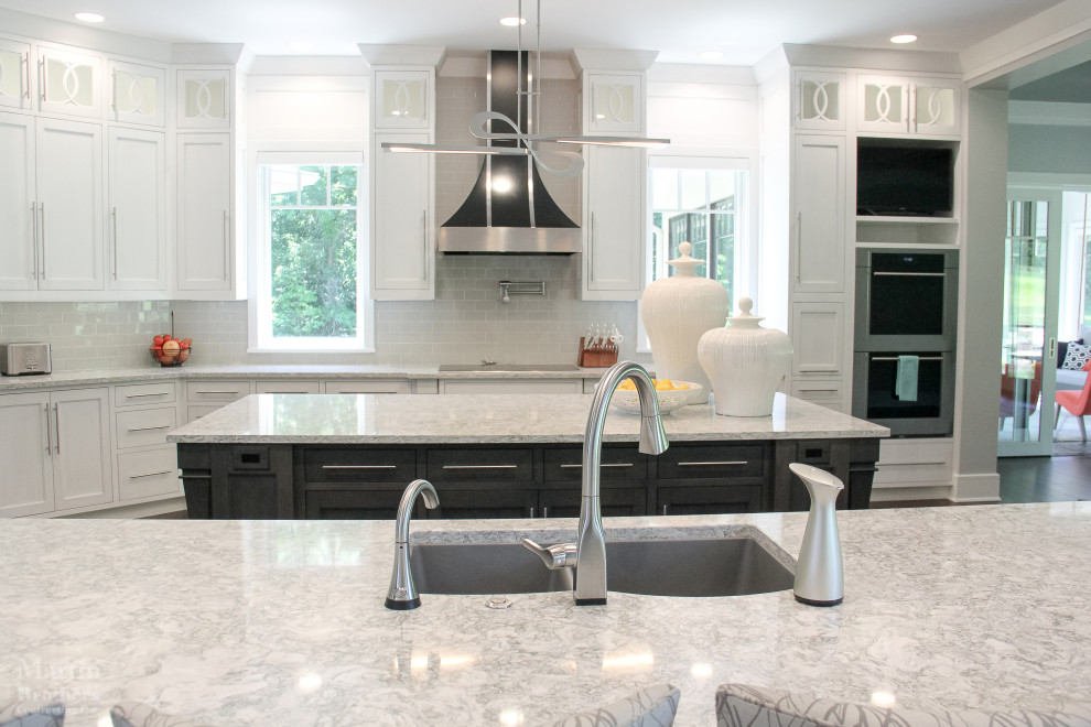 Kitchen pantry - huge transitional l-shaped dark wood floor kitchen pantry idea with an undermount sink, shaker cabinets, white cabinets, quartzite countertops, gray backsplash, ceramic backsplash, stainless steel appliances and two islands