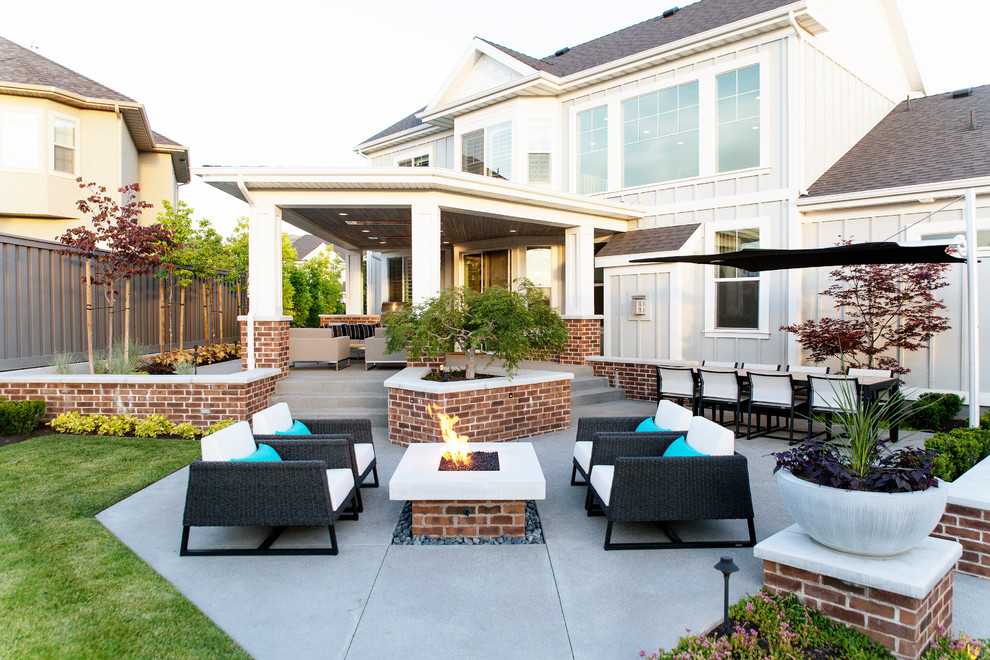 Photo of a transitional backyard patio in Salt Lake City with a fire feature, concrete pavers and a roof extension.