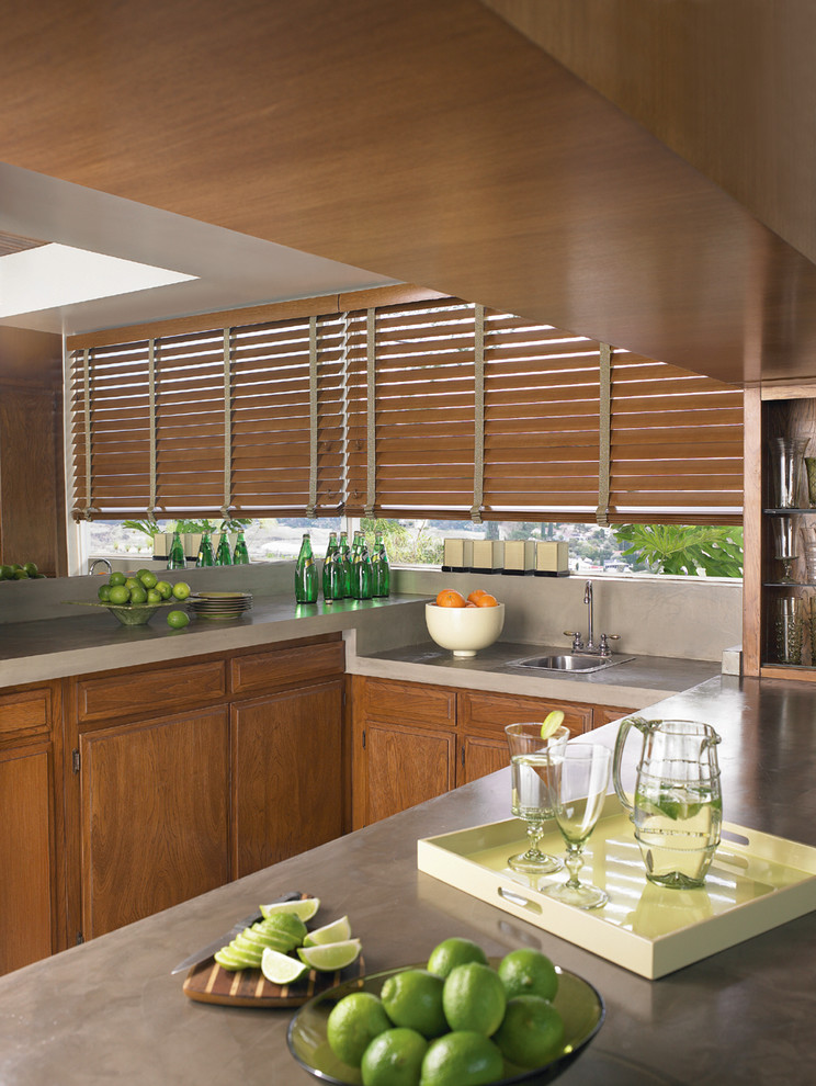 Inspiration for a mid-sized transitional u-shaped open concept kitchen remodel in Edmonton with a drop-in sink, raised-panel cabinets, medium tone wood cabinets, concrete countertops, stainless steel appliances and an island